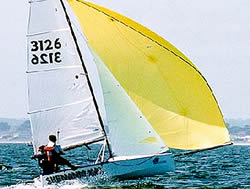 Dinghy sailing with a yellow spinnaker